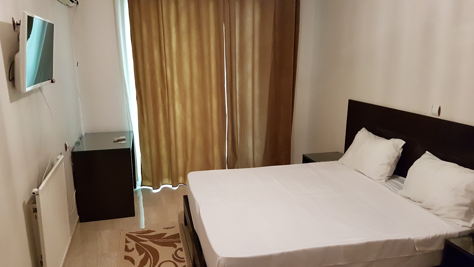 Bedroom with a double bed, flat-screen TV and radiator heater